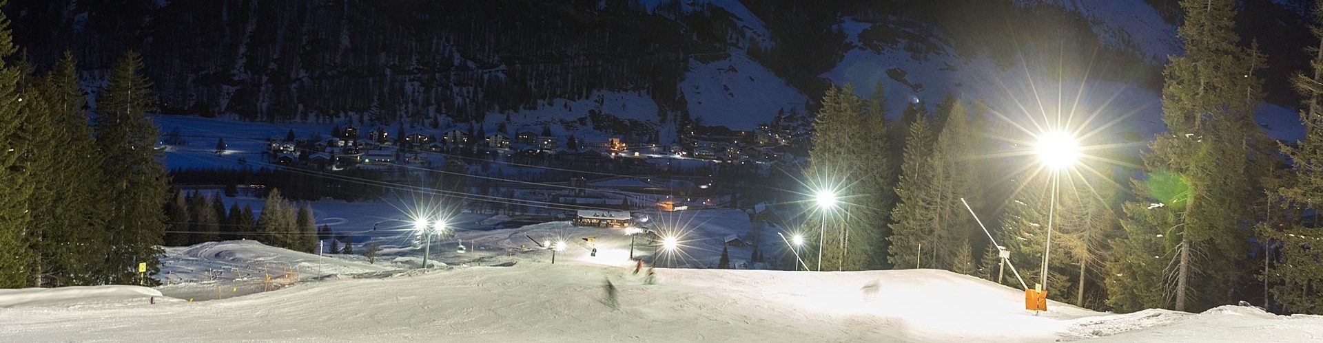 Nachtskifahren im Skigebiet Tambo mit Blick auf Dorf Splügen